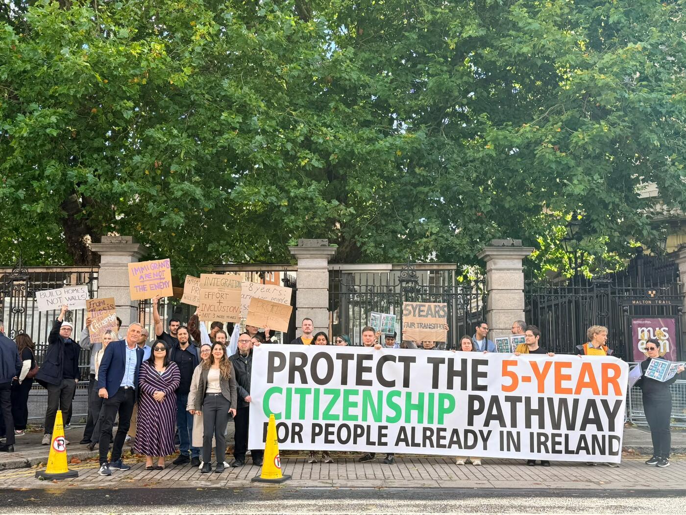 The banner ‘Protect the 5-year citizenship pathway for people already in Ireland’ at the gates of Leinster House on 30 September